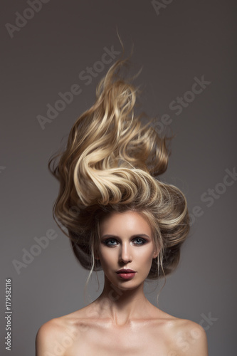 Portrait of blonde woman. Hair storm on her head.