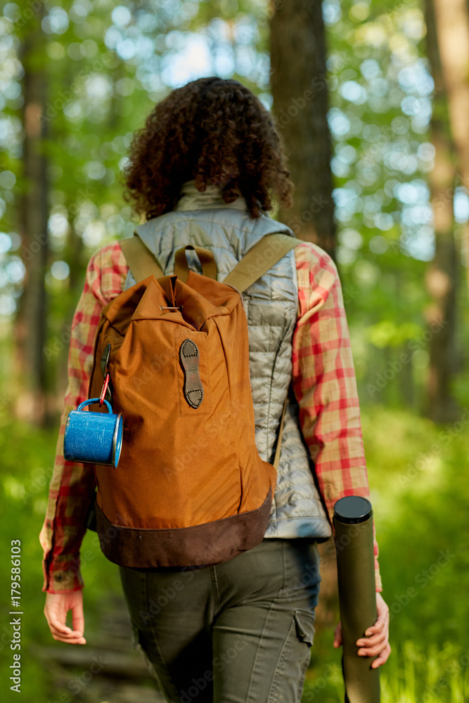 Woman backpacker hiking through woodland Woman backpacker hiking through woodland