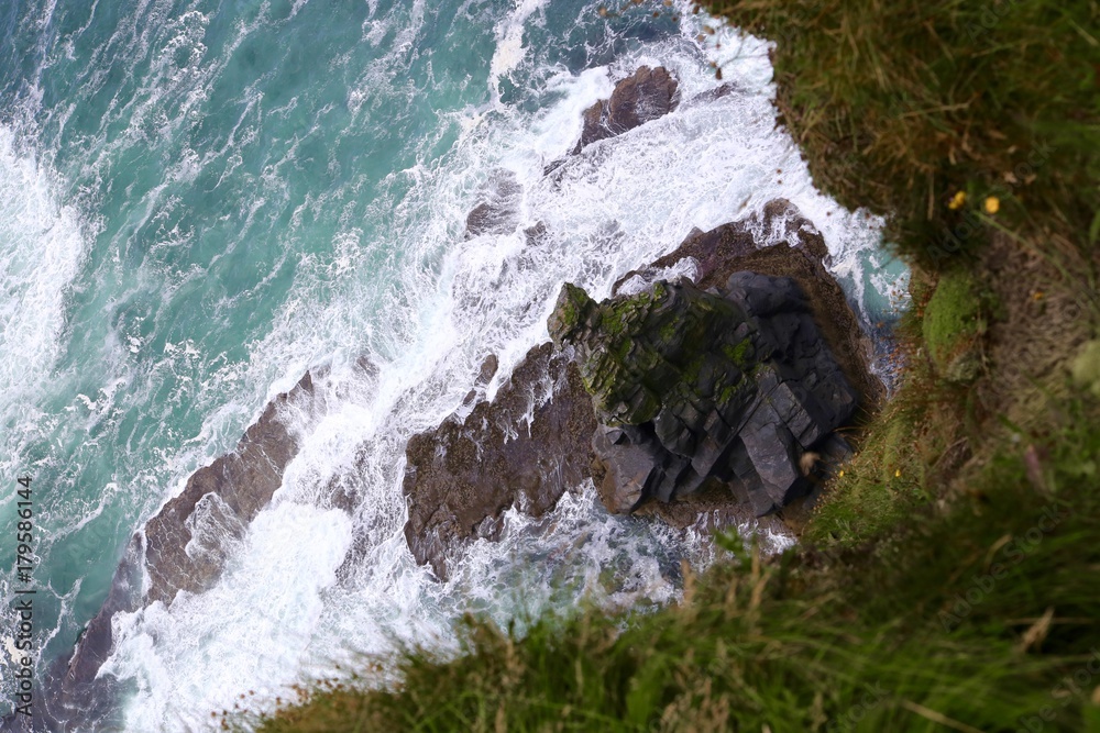 Looking Down the Cliffs of Moher Into Ocean in Ireland Looking Down the Cliffs of Moher Into Ocean in Ireland