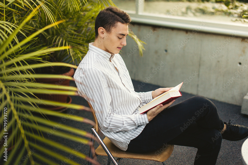 Man sit on the library and read book with blur background Stock Photo ...