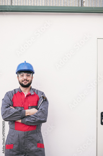 Worker posing in white wall background looking at camera