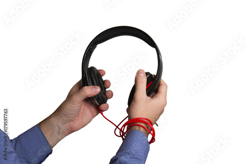 hand holding black plastic and leather big headphones isolated on a white background.