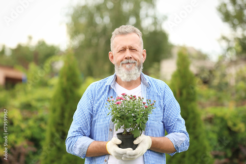 Elderly man holding bloomin...