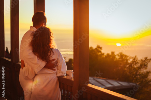 The bride and groom meet the dawn on the balcony.