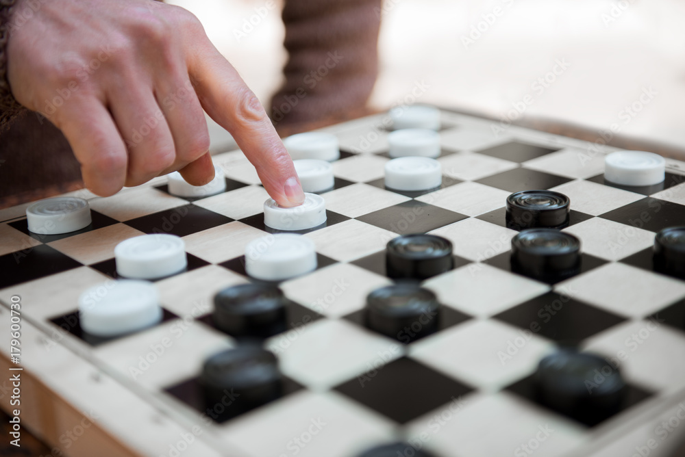 Naklejka premium Arm of man pushing chequer on board