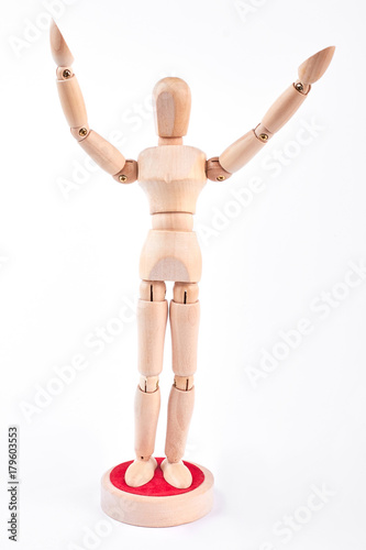 Wooden dummy standing with raised hands. Wooden mannequin raised hands over white background.