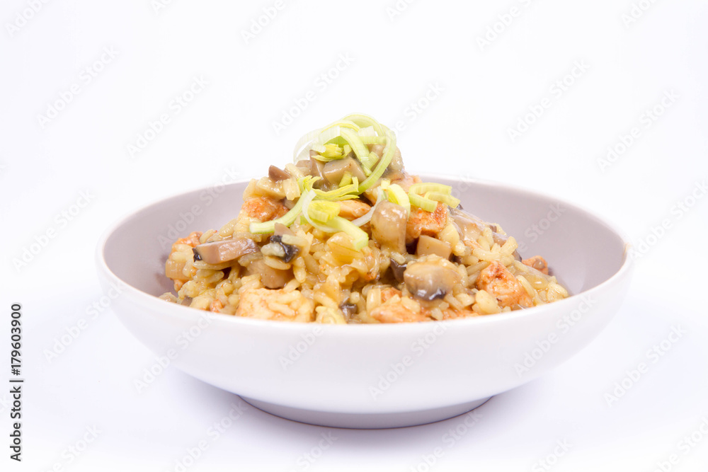 Risotto with mushrooms and chicken decorated with leek on a white background Risotto with mushrooms and chicken decorated with leek on a white background