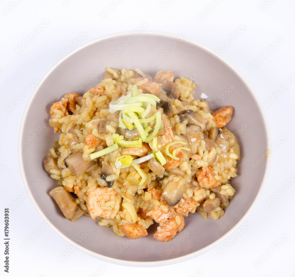 Risotto with mushrooms and chicken decorated with leek on a white background