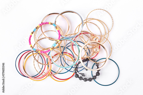Collection of stylish bracelets, top view. Stack of different wrist bands for women, white background. Female bangles on sale.
