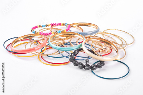 Many bracelets on white background. Collection of women fashion bangles. Female jewelry on white background.