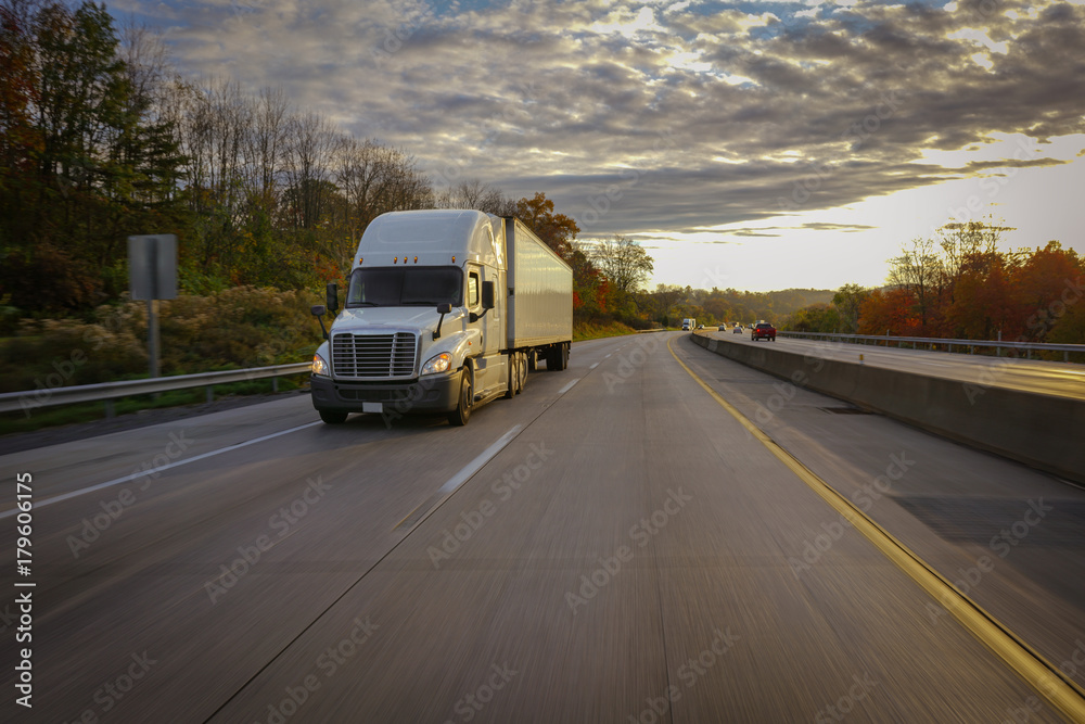Semi truck on highway at sunset