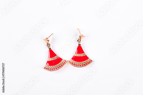 Fashion earrings on white background. Red and gold stylish jewelry earrings over white background. Woman luxury accessory.