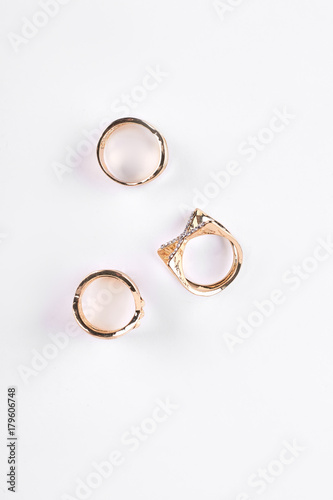 Three bijouterie rings, top view. Girls rings with zirconium isolated on white background. Woman fashion jewelry.