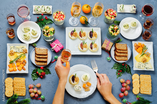 Christmas appetizers celebration table setting with woman's hands