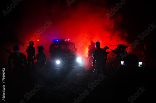 Anti-riot police give signal to be ready. Government power concept. Police in action. Smoke on a dark background with lights. Blue red flashing sirens.