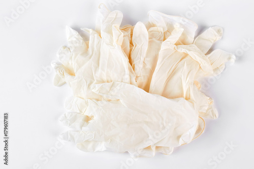 Pile of white medical gloves. Heap of thin latex medical gloves isolated on white background. Medicine and health care concept.