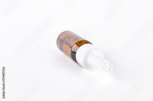 Nasal spray with plastic sprayer. Medication to treat running nose isolated on white background. Amber bottle of nose drops.
