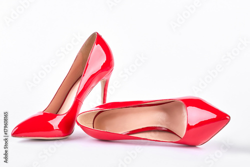 Classic red shoes on high heels. Woman red elegant shoes on heels over white background. Female beautiful accessory.