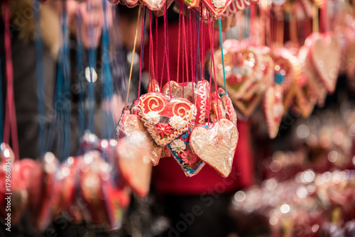 Decorated gingerbread hearts hanging on open market stall during holidays 