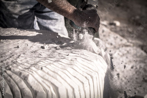 Artista che scolpisce il marmo con un martello pneumatico
