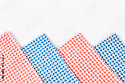 Plaid table napkins, white background. Collection of red and blue checkered tablecloth on white background close up. Row of vintage table napkins.