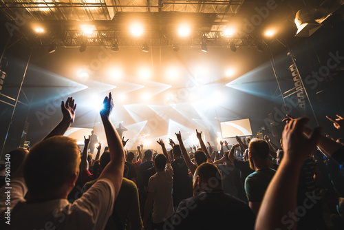 silhouettes of concert crowd in front of bright stage lights