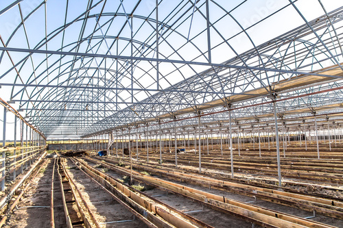 Metal frame of a greenhouse against the sky © kvdkz