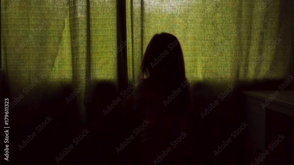 Little girl goes to the window and opens the curtain, slow motion Little girl goes to the window and opens the curtain, slow motion