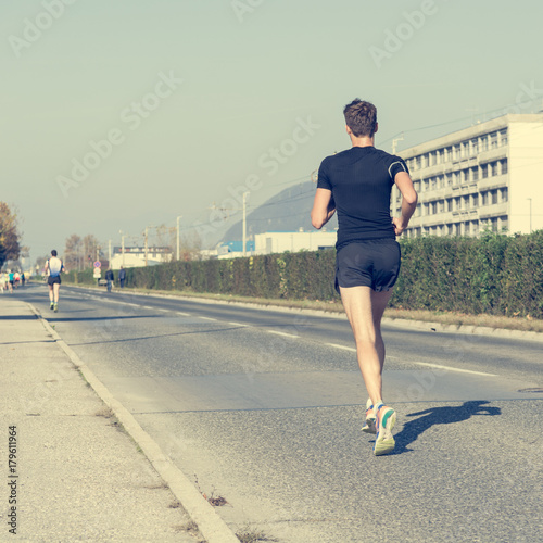 Lonely marahon runner catching up. photo