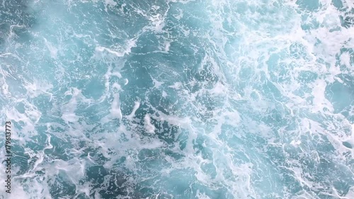 Deep blue stormy sea water surface with white foam and waves photo