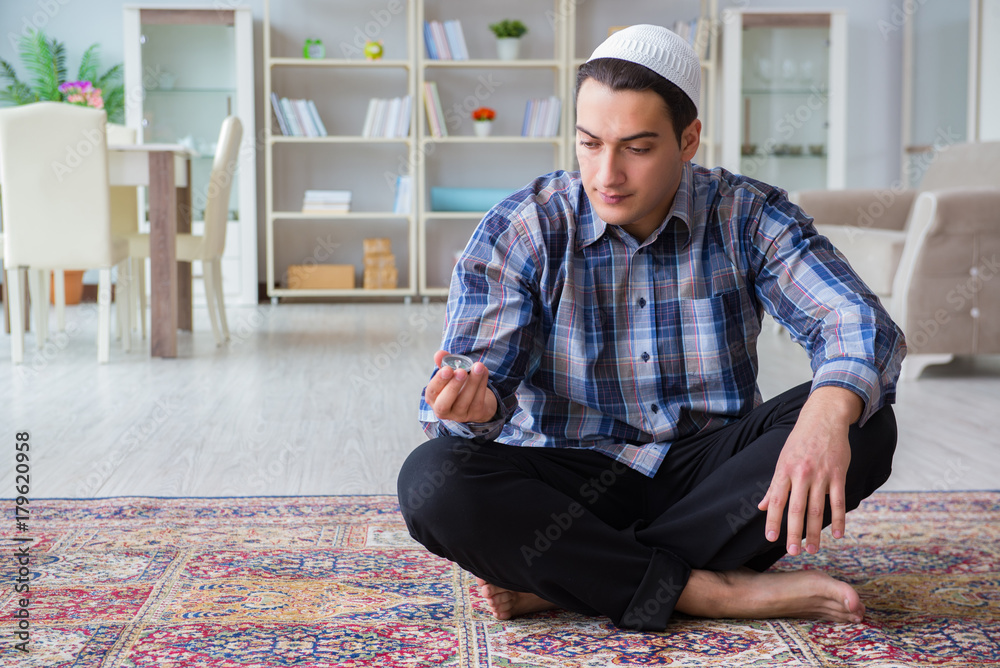 Fototapeta premium Young muslim man praying at home