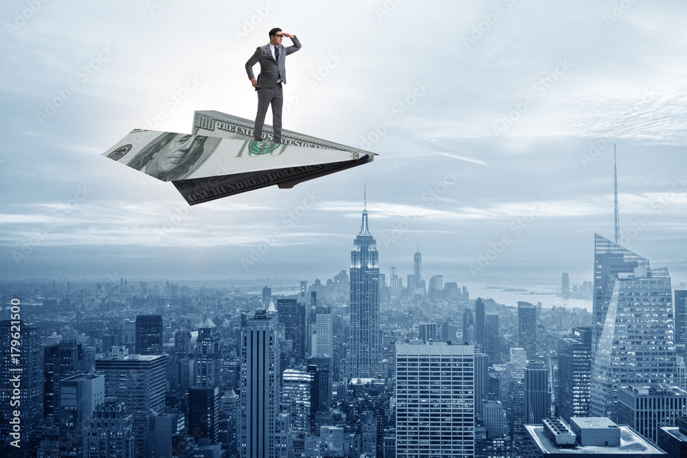 Businessman flying on paper plane in business concept Businessman flying on paper plane in business concept