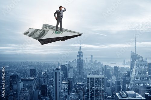 Businessman flying on paper plane in business concept