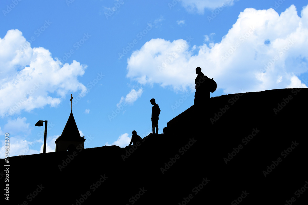 Silhouettes of people on the roof of houses. 