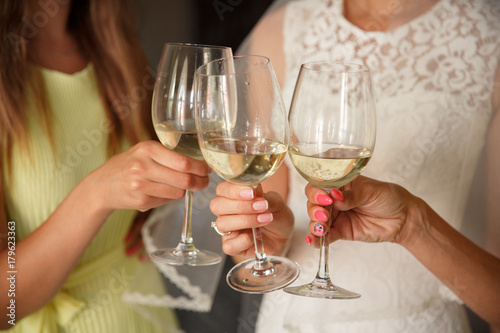 Wedding party, bride clinks to the bridesmaids with champagne glasses. Wedding or hen party concept