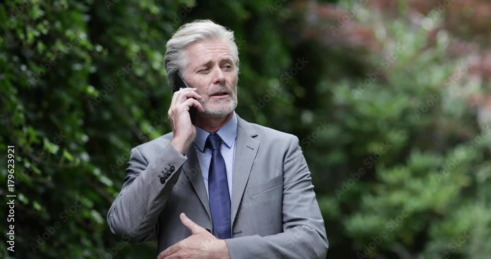 Senior business executive using a smartphone outdoors Senior business executive using a smartphone outdoors