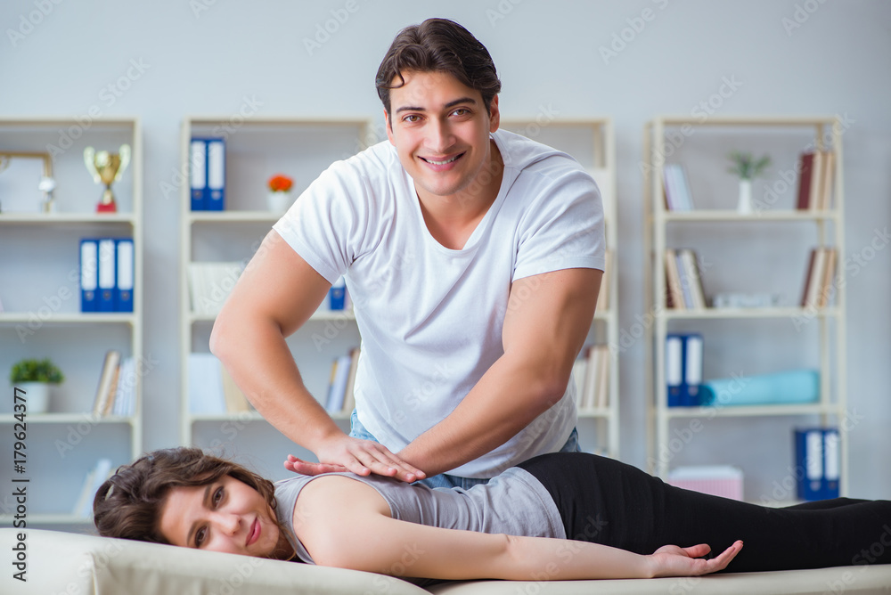 Fototapeta premium Young doctor chiropractor massaging female patient woman