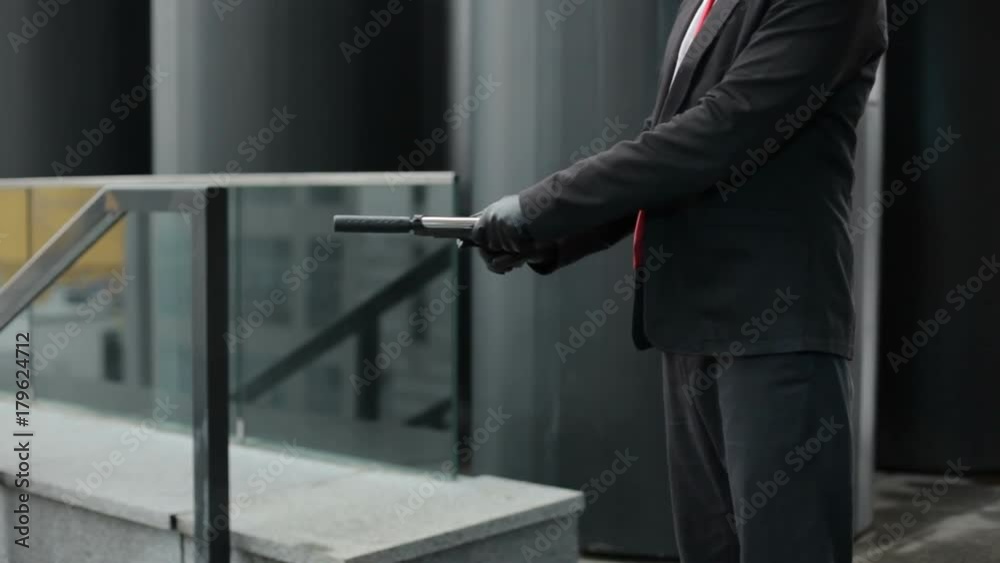 In the hands of a pistol with a silencer. In the hands of a pistol with a silencer.