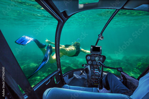 Underwater submarine ship following a woman in apnea swimming in tropical turquoise sea of Racha Noi, Phuket in Thailand. cockpit interior view