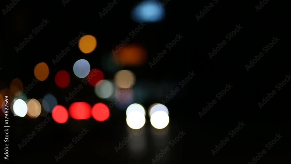 Night colorful bokeh lights and out of focus cars of city traffic