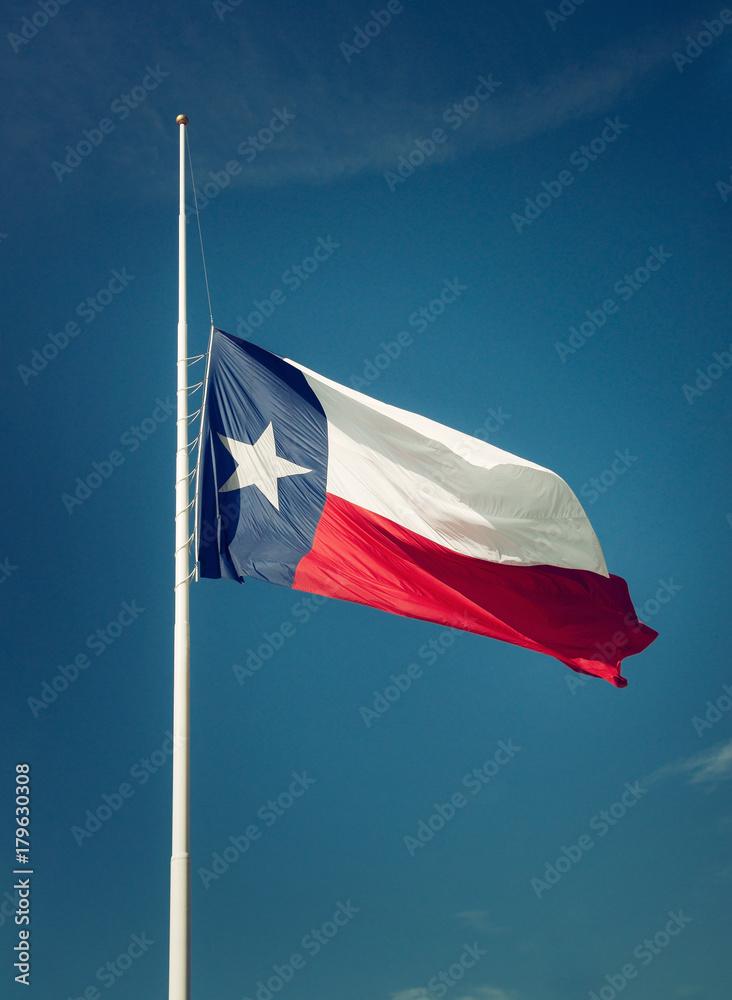 State flag of Texas flying at halfmast or halfstaff on a flagpole