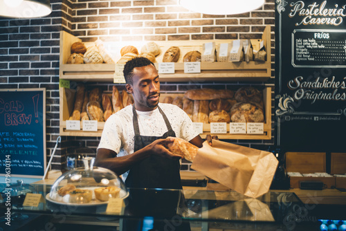 Black man sells in bakery.