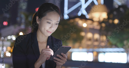 Photography Businesswoman working on mobile phone in city at night