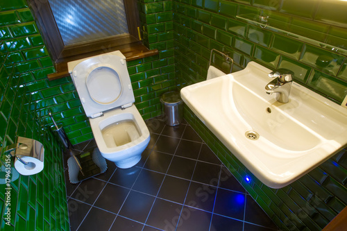 Toilet room with green tiles.