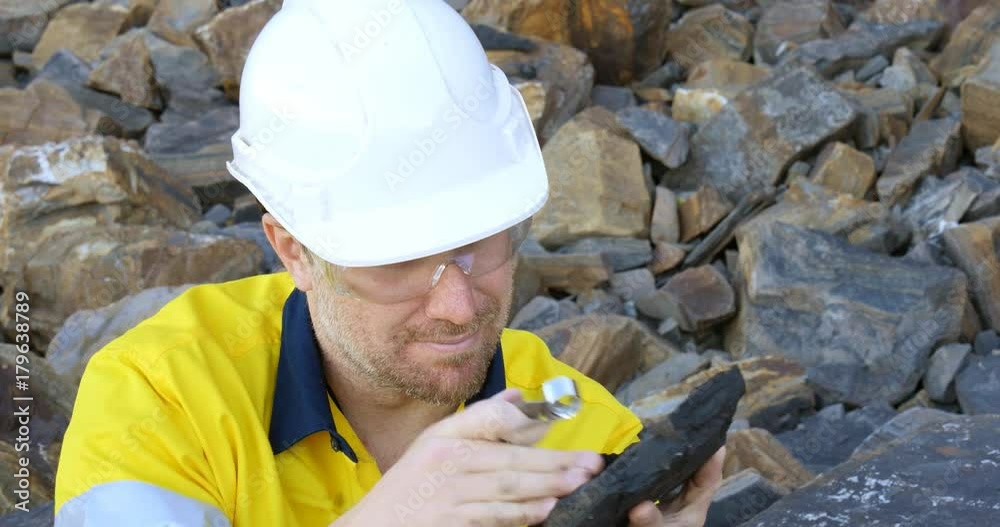 Geologist engineer man examines coal sedimentary layer for mining industry