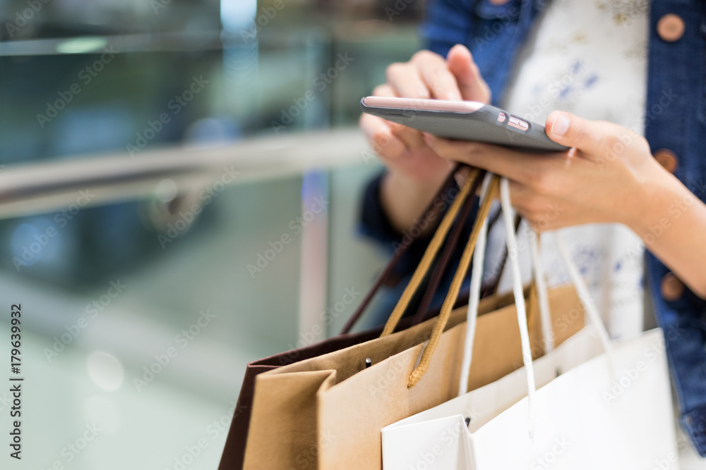 Obraz premium Shopping woman using cellphone
