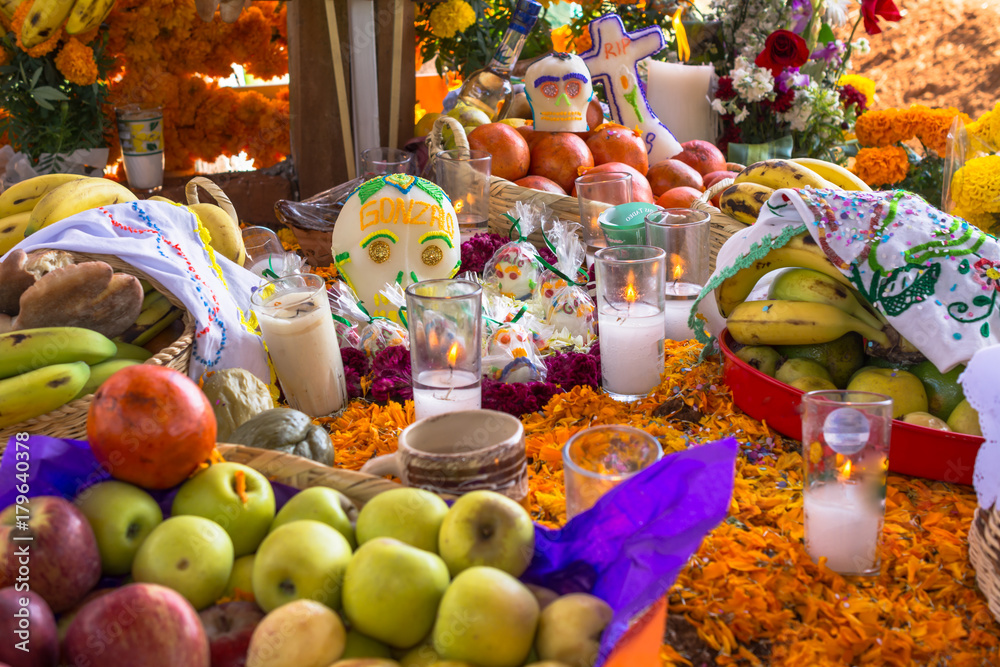El altar de muertos tiene muchas frutas y objetos.