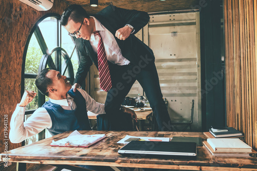 Businessman fighting with his coworker in office. photo