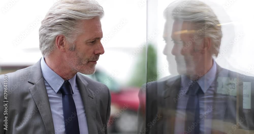 Senior man looking in store window Senior man looking in store window