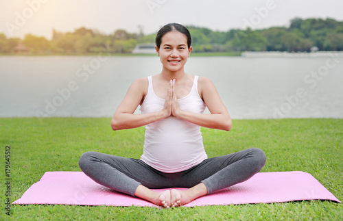 healthy pregnant woman doing yoga in nature outdoors.